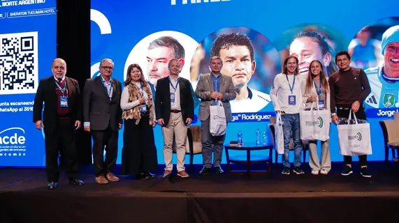 Foto grupal sobre el escenario al cierre del 6.º Encuentro