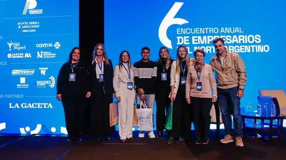 Participantes frente a la pared de sponsors del 6.º Encuentro