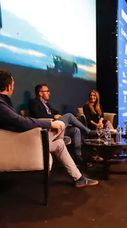 Conversación entre disertantes en los sillones del escenario